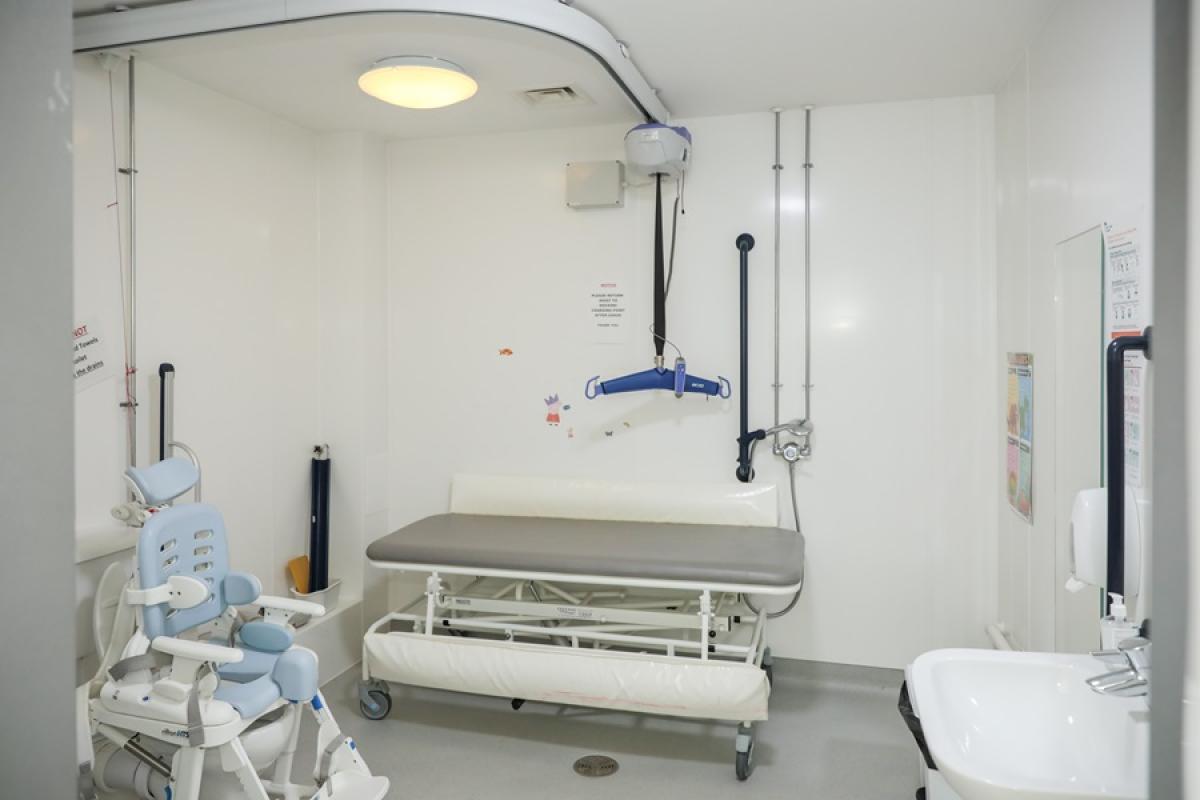 Accessible bathroom showing wet room with hoist and bathroom chair