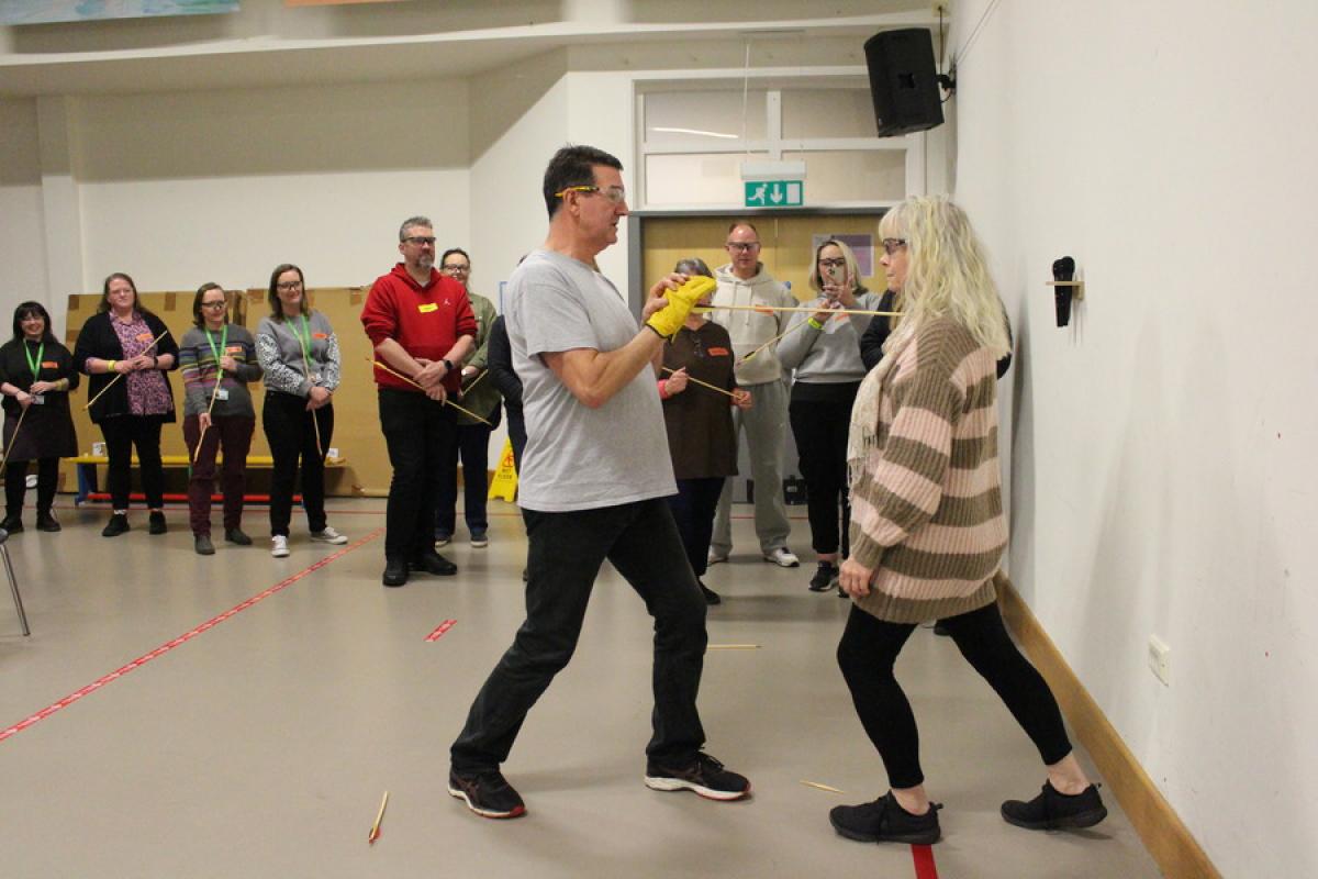 Firewalk participant breaking an arrow with her chest during the seminar 