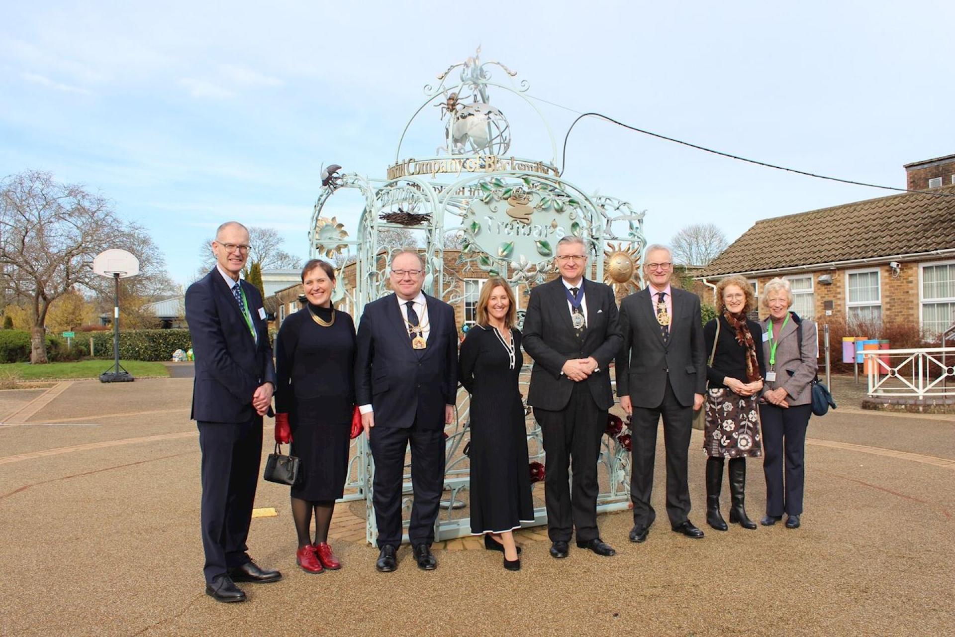 the Lord Mayor of the City of London, Alderman Alastair King and the Representative Lady Mayoress, Corinne Lee, with guests pose in front of the Blacksmiths's archway at Treloar's