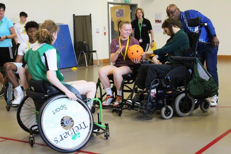 Students from HSDC Alton College playing inclusive sports with Treloar's students: here Alton College student is receiving a ball from Treloar's student.