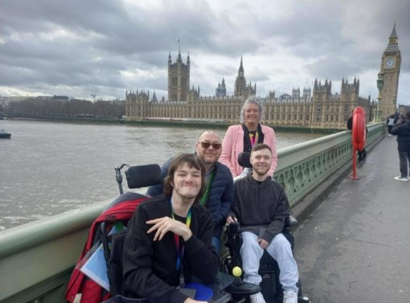 2 Treloar College students with 2 teachers posing for a photo on a Westminster bridge - Westminster and Big Ben in the distance.