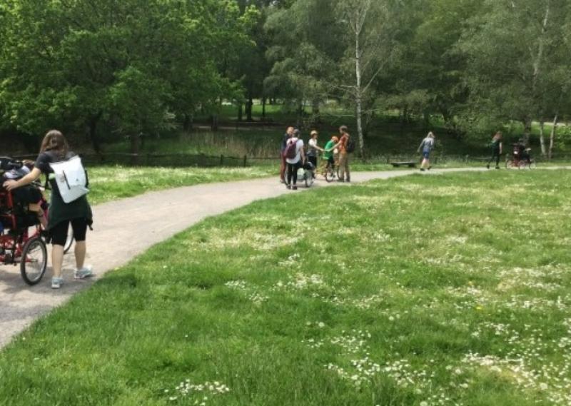 Student on the summer term DofE expedition walking along a path in the middle of a green meadow.