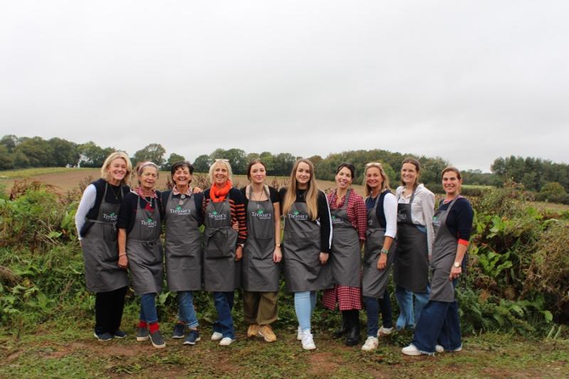 The Dummer Fair Committee with Treloar's Events Team in a group shot all wearing Treloar's aprons with the fields in the background.