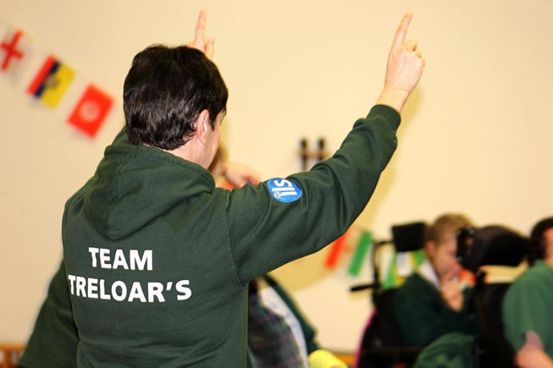 reloar's staff member wearing a dark green hoodie with a writing on the back: TEAM TRELOAR'S