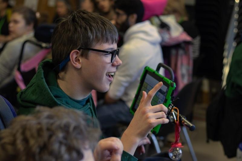 Treloar School student during an assembly using his iPad.