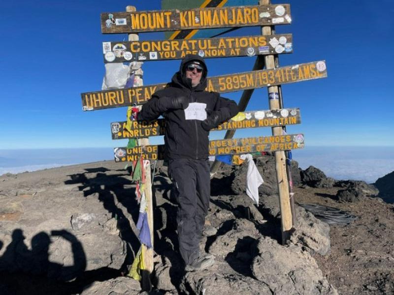 Chris reached the peak of Kilimanjaro - posing in front of a signpost.