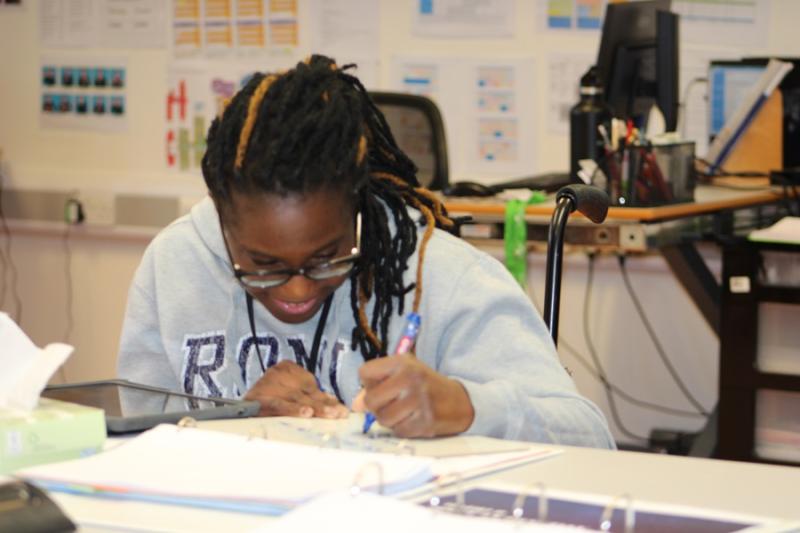 Treloar's student at her desk making notes.