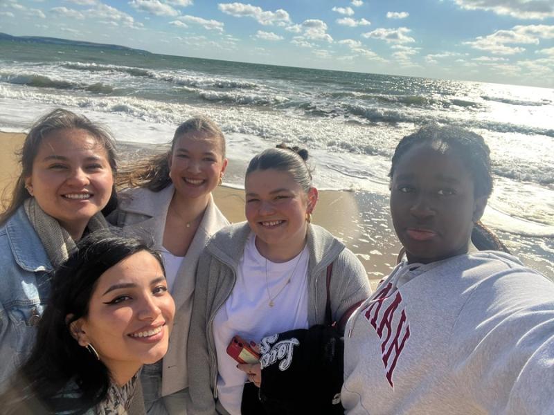 Treloar's international volunteers on the beach taking a selfie on a sunny day, sea in the background.