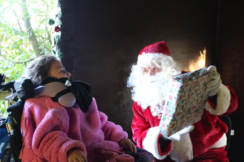 Treloar's primary student is being presented with a Christmas gift by Santa. 