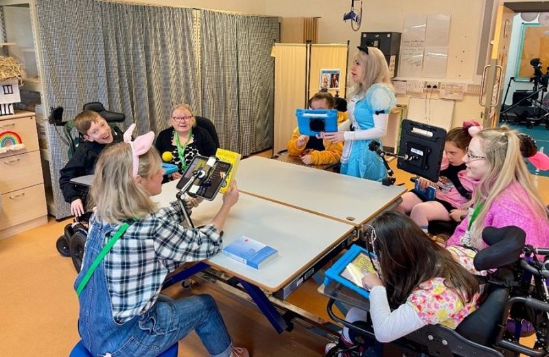 Treloar's students and staff during a whole class reading session in the classroom during World Book Day. Students and staff are dressed up as book characters.