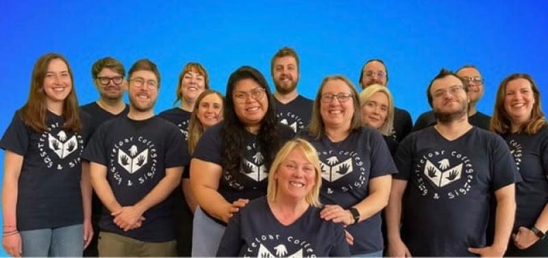 A group photo of Treloar College Sing and Sign Team, consisting of Makaton tutors and Treloar's staff. All wearing matching T-shirts.