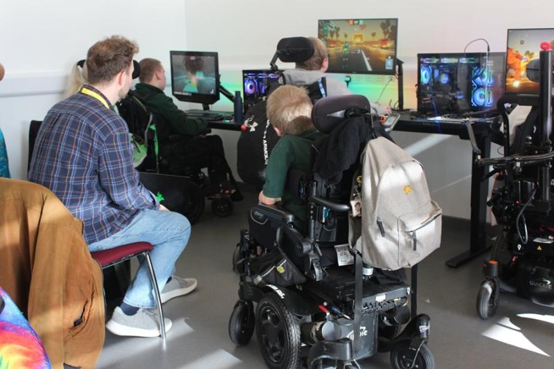 Oscar Salandin, a game designer, during a session in Treloar's Interactive Learning Zone for students interested in game development. Oscar is sitting on a chair watching 3 Treloar's students test his game.