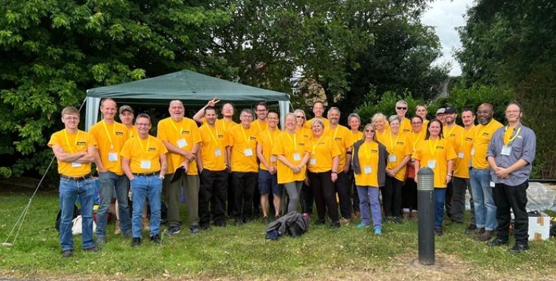 A group photo of corporate volunteers at Treloar's, all wearing their branded, yellow T-shirts.