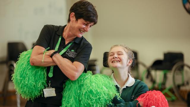 Member of staff laughing with a student