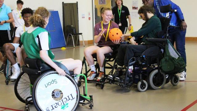 Students from HSDC Alton College playing inclusive sports with Treloar's students: here Alton College student is receiving a ball from Treloar's student.