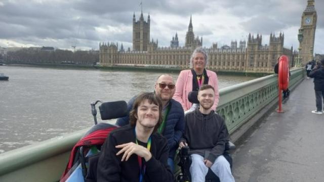 2 Treloar College students with 2 teachers posing for a photo on a Westminster bridge - Westminster and Big Ben in the distance.