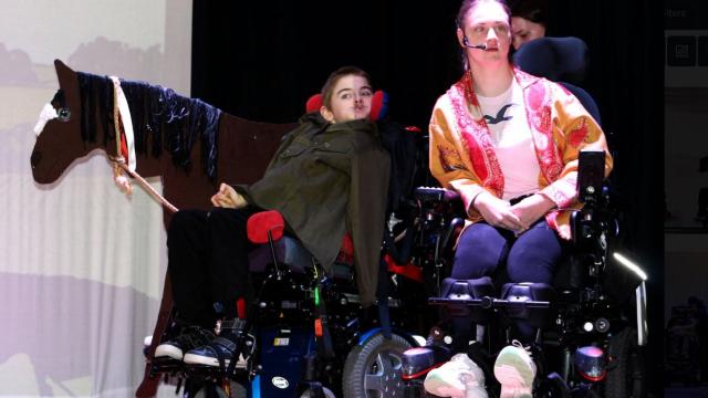 2 Treloar's students on stage during the War Horse performance; in the background, there is a horse made out of cardboard.