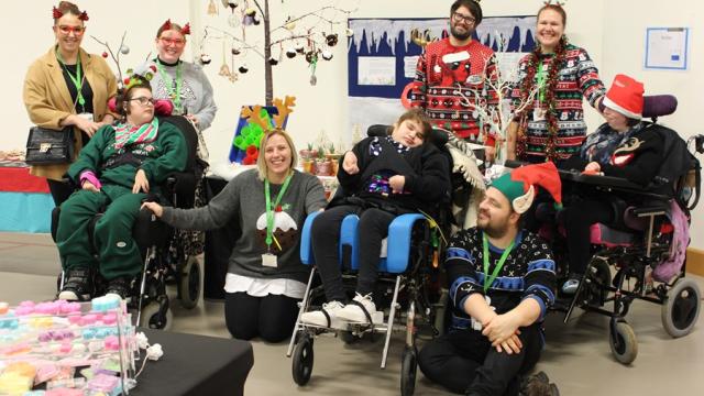 Treloar's students and staff at Christmas Fair wearing Christmas hats and jumpers.