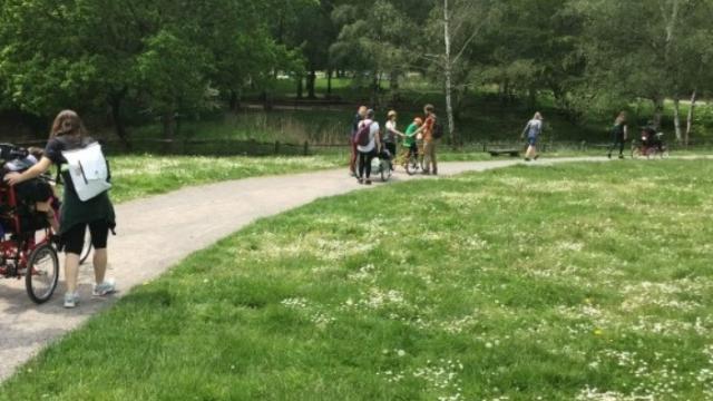 Student on the summer term DofE expedition walking along a path in the middle of a green meadow.