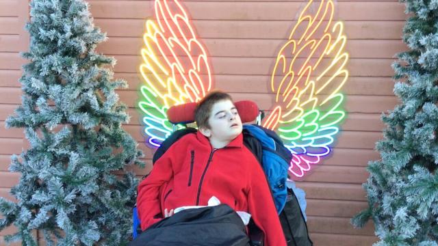 Treloar student in front of angel wings lights