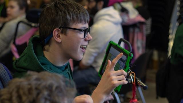 Treloar School student during an assembly using his iPad.