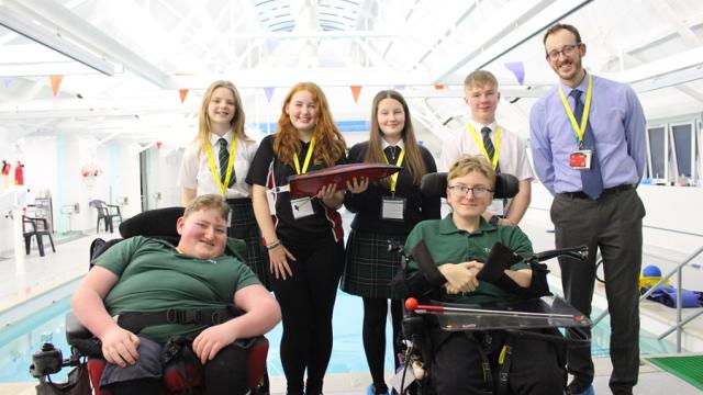 Will Redfearn, STEM teacher at Eggar's school, together with a group of Eggar's students and 2 Treloar School student in a group shot at Treloar's pool.reloar’s enjoyed a fun afternoon session exploring the idea of floatation in regard to boats. 