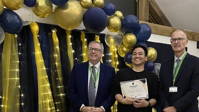 Zizan Rozman, Treloar's Team Leader at Evans House, holding his certificate at the Celebration of Success event