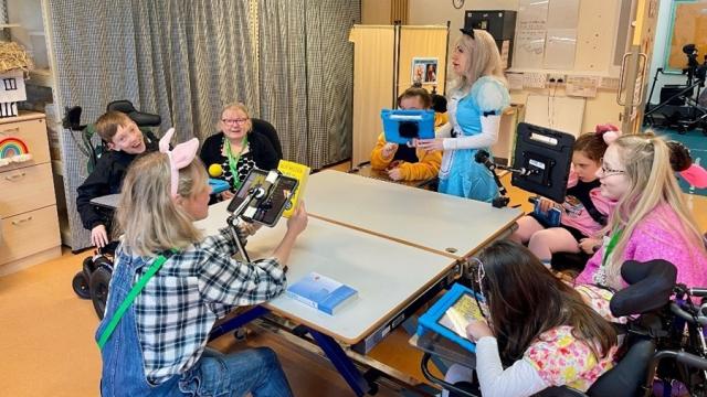 Treloar's students and staff during a whole class reading session in the classroom during World Book Day. Students and staff are dressed up as book characters.