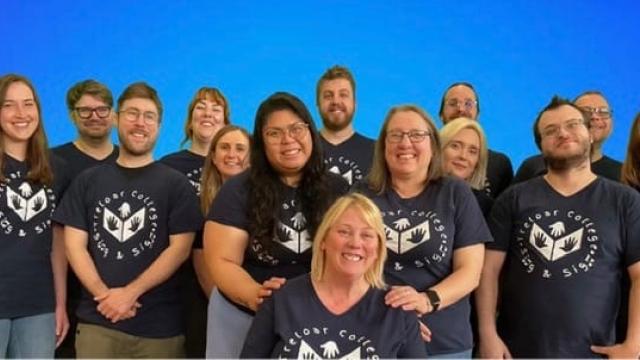 A group photo of Treloar College Sing and Sign Team, consisting of Makaton tutors and Treloar's staff. All wearing matching T-shirts.