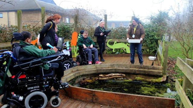 Deadwater Valley Trust Rangers leading a session in Treloar's outdoor learning area, here at the pond, conducting a practical outdoor activity and showing Treloar's students what organisms live in the water.