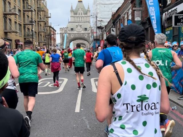 Treloar's supporter running London Marathon and wearing a branded running top with Treloar's logo at the back and green dots all over.