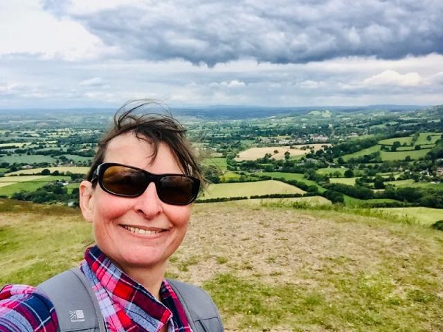 Elaine during one of her walks: she is wearing black sunglasses; in the background Malvern view