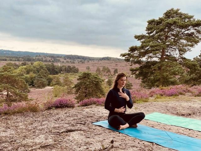 Well-being champion Sophie sitting on a matt while doing a breathing yoga exercise