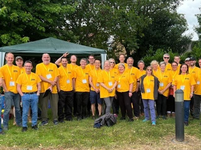 A group photo of corporate volunteers at Treloar's, all wearing their branded, yellow T-shirts.