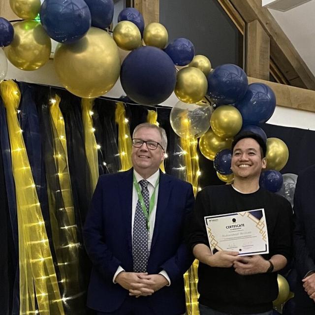 Zizan Rozman, Treloar's Team Leader at Evans House, holding his certificate at the Celebration of Success event