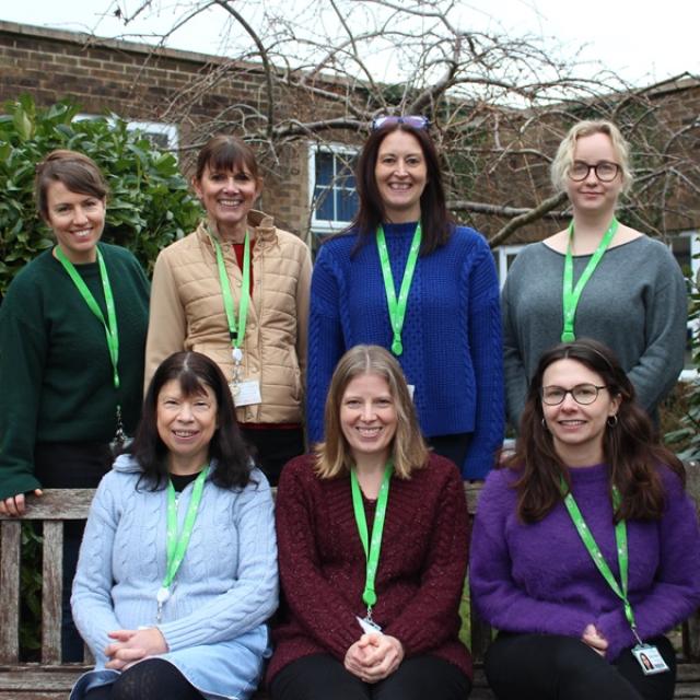 Group photo of Treloar’s Counselling Team done outdoors: 3 members of the team are sitting on a bench and 4 members are standing right behind the bench. 