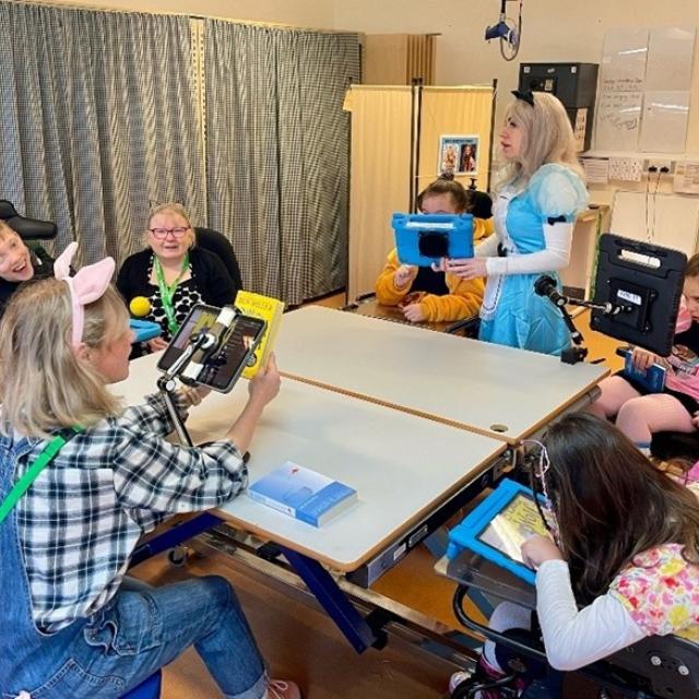 Treloar's students and staff during a whole class reading session in the classroom during World Book Day. Students and staff are dressed up as book characters.